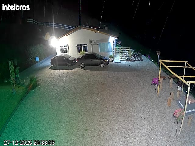 Vista noturna da casa e estacionamento